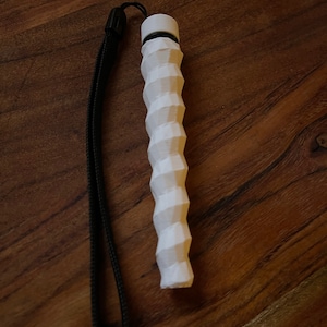 May include: White, textured, grip-style camera strap with a black strap. The strap is made of a flexible material and has a textured surface.