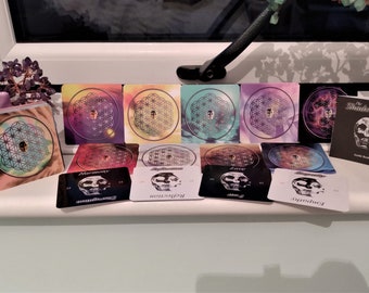 May include: A set of 10 cards with a geometric pattern and a skull image. The cards are arranged in two rows. The top row has five cards with different colored backgrounds. The bottom row has five cards with black backgrounds and white skull images. The cards are labeled with words like "Harmony", "Transformation", "Love", and "Opportunity". The cards are part of a deck called "The Shadow Light Cards".