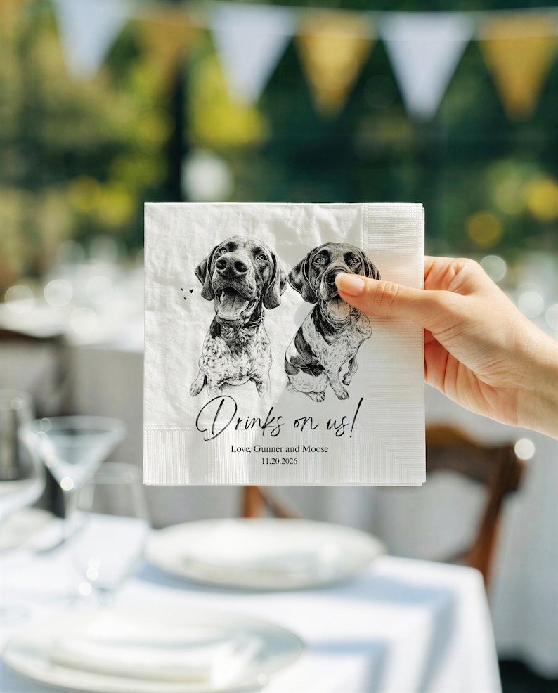 May include: A white square paper napkin featuring a black and white sketch of two dogs. The text reads "Drinks on us!" followed by "Love, Gunner and Moose" and the date "11.20.2026". The napkin has a textured border and a matte finish.