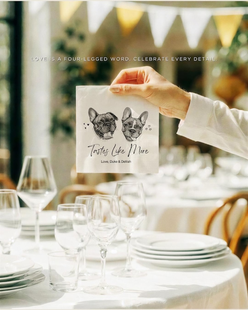May include: A white square paper napkin featuring a black and white illustration of two French Bulldogs, the text "Tastes Like More" in a cursive script, and the printed names "Love, Duke & Delilah" with small heart icons on the sides.