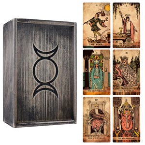 May include: A wooden tarot card box with a silver finish and a black triple moon symbol. The box is displayed with several tarot cards featuring illustrations and titles such as "The Fool" and "The Magician."