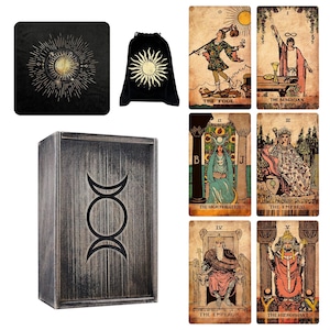 May include: A collection of tarot cards, a black velvet bag with a sun design, a black square mat with a sun design, and a wooden box with a triple moon symbol. The tarot cards feature illustrations and titles.