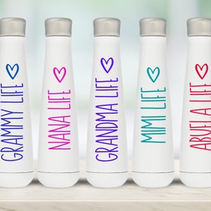 K&ouml;nnte beinhalten: F&uuml;nf wei&szlig;e Wasserflaschen mit unterschiedlich farbigem Text und einem Herz-Design. Der Text auf den Flaschen lautet "Grammy Life", "Nana Life", "Grandma Life", "Mimi Life" und "Abuela Life".
