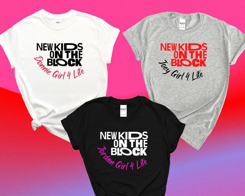 K&ouml;nnte beinhalten: Drei T-Shirts mit dem Text "New Kids on the Block" in schwarzer und roter Schrift. Die Shirts sind wei&szlig;, grau und schwarz. Jedes Shirt hat einen anderen Namen unter dem Text gedruckt: Donnie, Joey und Jordan. Der Text "Girl 4 Life" ist in rosa unter dem Namen gedruckt.