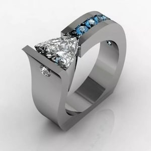 May include: A silver ring with a triangular diamond and a row of blue gemstones. The ring has a unique, modern design.