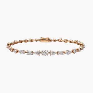 May include: Rose gold bracelet with a series of alternating diamond shapes, including round, pear, and emerald cuts. The bracelet is secured with a clasp. The bracelet is set against a white background.
