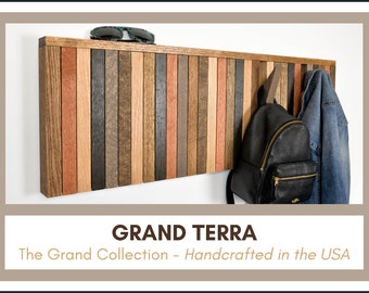 May include: A wooden wall-mounted coat rack with a shelf on top. The rack is made of multiple wood planks in various shades of brown, red, and black. A pair of sunglasses is on the shelf, and a backpack and jacket are hanging on the hooks. The rack is labelled "GRAND TERRA The Grand Collection - Handcrafted in the USA".