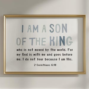 May include: A framed print with the text "I AM A SON OF THE KING" in blue and grey lettering. The print includes a Bible verse from 2 Corinthians 6:18. The frame is gold, and the background is white.