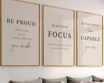 May include: Three vertical wall art prints in thin gold frames featuring motivational text on a light beige background. The first reads BE PROUD of the work you do and the difference you make. The second reads KEEP YOUR FOCUS on what you can control and let the rest go. The third reads NEVER FORGET how CAPABLE you are.