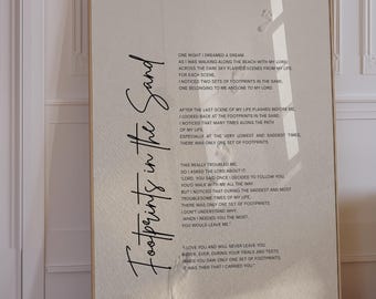 May include: A rectangular wall art print featuring the text Footprints in the Sand in a large black script font on the left side, with the full poem printed in smaller black text on a light beige background with faint footprint imagery.