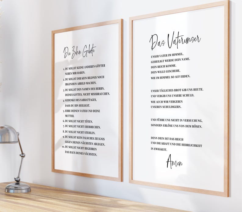 May include: Two framed prints with light wood frames. The left print features the text "Die Zehn Gebote" in black, with a list of commandments below. The right print displays "Das Vaterunser" in black script, with a prayer below.