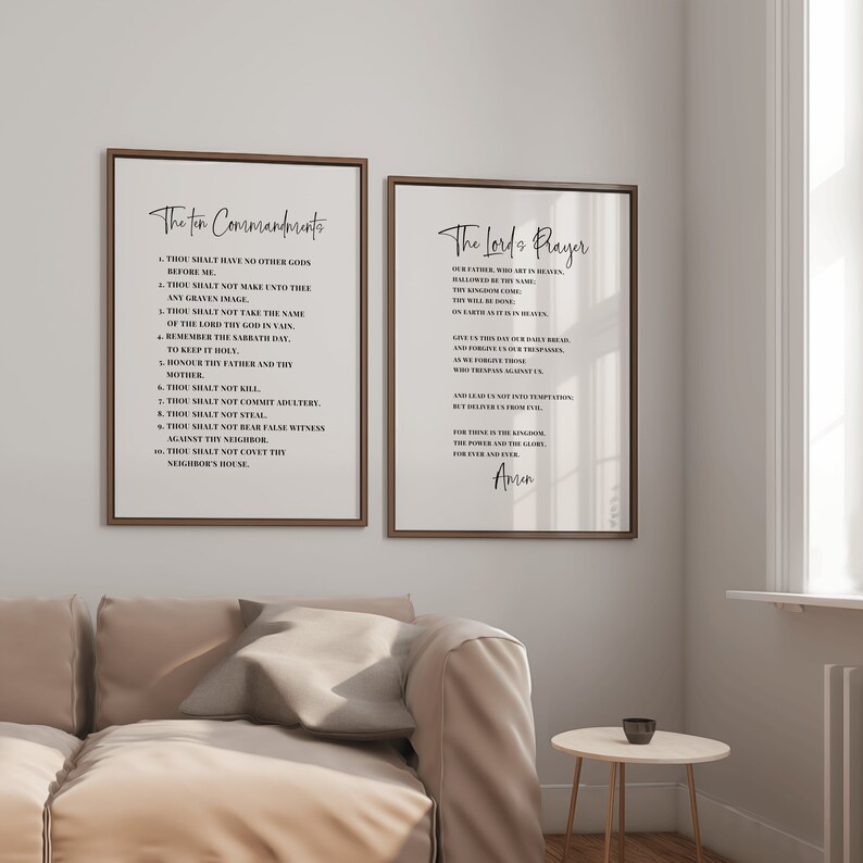 May include: Two framed wall art prints. One print displays "The Ten Commandments" and the other displays "The Lord's Prayer". Both prints have a white background with black text and are framed in a brown wooden frame.