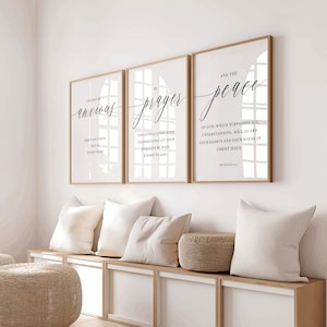 May include: Three framed prints with inspirational quotes about prayer and peace. The prints are in black and white and feature a window-like design. The quotes are "Do not be anxious about anything, but in everything by prayer and supplication with thanksgiving let your requests be made known to God." and "And the peace of God, which surpasses all understanding, will guard your hearts and your minds in Christ Jesus."