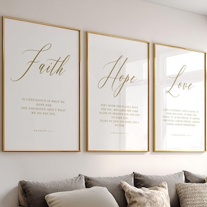 Può includere: Tre stampe artistiche incorniciate con cornici dorate e sfondi bianchi. Le stampe presentano le parole "Fede", "Speranza" e "Amore" in elegante scrittura dorata. Ogni stampa include un testo ispiratore.
