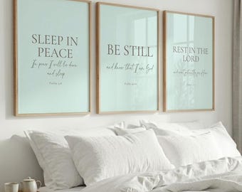 May include: Three rectangular wall art prints with light mint green backgrounds and dark gray text. The prints feature the phrases Sleep in Peace, Be Still, and Rest in the Lord, each accompanied by a Bible verse reference in a serif font.