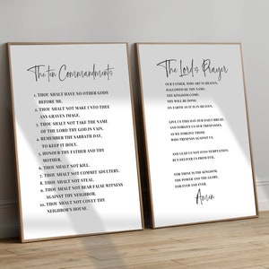 May include: Two framed prints with black text on a white background. The left print displays "The Ten Commandments" and the right print displays "The Lord's Prayer". Both prints have a simple, elegant design with a wooden frame.