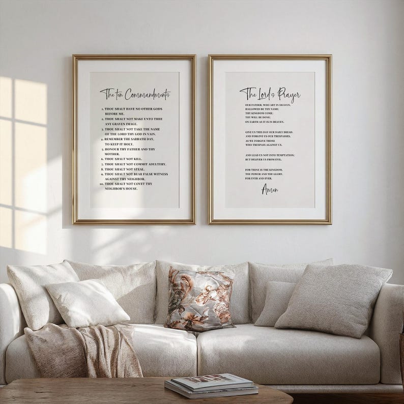 May include: Two framed prints with gold frames hang above a beige sofa. The left print displays "The Ten Commandments" in black script, while the right print features "The Lord's Prayer." The prints add a touch of spirituality to the living room.