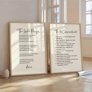 May include: Two framed prints with beige mats and light wood frames. The left print displays "The Lord's Prayer" in elegant script, while the right print features "The Ten Commandments." Both are set against a neutral background, creating a serene aesthetic.