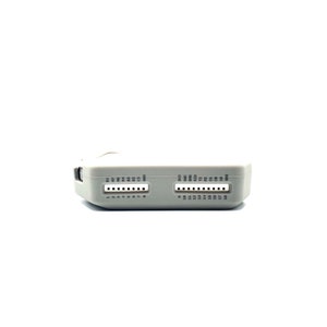 Op de afbeelding: Een lichtgrijs elektronisch apparaat met twee rijen pinconnectoren. Elke rij heeft genummerde pinnen. Het apparaat heeft tekstlabels boven de pinnen. De achtergrond is wit.