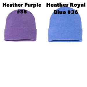 May include: Two knit beanies in heather colors. One is heather purple with the number 35, and the other is heather royal blue with the number 36. The beanies are folded at the bottom.