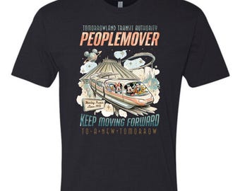 May include: A black short-sleeve t-shirt featuring a graphic of the Tomorrowland Transit Authority PeopleMover with cartoon characters. Text includes "TOMORROWLAND TRANSIT AUTHORITY PEOPLEMOVER", "Moving People Since 1975", and "KEEP MOVING FORWARD TO A NEW TOMORROW".