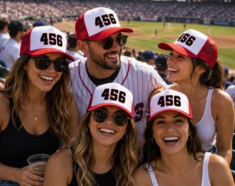 May include: A red and white trucker hat featuring the number 456 in bold black font on the front panel. The hat has a structured white front, a red brim, and a red mesh back. This design is consistent across multiple hats worn in the image.