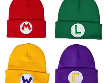 May include: Four knit beanies in red, green, yellow, and purple. Each beanie features a folded cuff with a circular white patch centered on the front. The patches display the embroidered letters M, L, W, and a reversed L in matching colors.