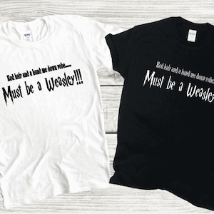 May include: Two t-shirts with the text "Red hair and a hand me down robe... Must be a Weasley!!!" printed on them. One t-shirt is white and the other is black.