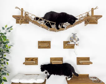 May include: A wall-mounted cat tree with multiple shelves and a hanging rope bridge. Two black cats are playing on the shelves and bridge. The shelves are made of wood and have a natural finish. The bridge is made of rope and has a natural color. The cat tree is a great way to provide your cat with a place to play, climb, and relax.