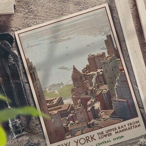 May include: Vintage travel poster featuring a bird's eye view of the New York City skyline with the text "The Upper Bay from Lower Manhattan, Central System, New York".