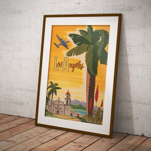 Puede incluir: Un cartel de viaje vintage para Los &Aacute;ngeles, California. El cartel presenta una palmera, un edificio de estilo misi&oacute;n y un avi&oacute;n volando por encima. El texto "Los &Aacute;ngeles" est&aacute; escrito en una fuente estilizada.