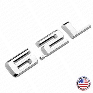 May include: Chrome 6.2L emblem with a raised design. The emblem is made of metal and has a shiny finish.