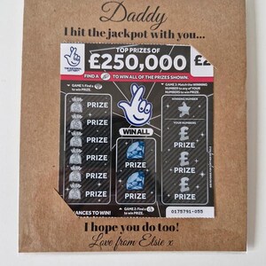 May include: A greeting card with a lottery ticket design. The card is brown with the words "Daddy, I hit the jackpot with you..." printed on it. The lottery ticket shows prizes and the text "I hope you do too! Love from Elsie x."