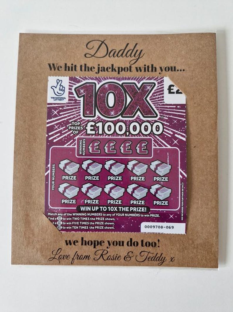 May include: A greeting card with a lottery scratch-off ticket. The card is brown with the word "Daddy" at the top. The scratch-off ticket is purple and features the text "10X" and "&pound;100,000". The card includes the message "We hit the jackpot with you..." and "Love from Rosie & Teddy x".