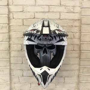 May include: White motorcycle helmet with a black and white skull graphic and the text "Airoh Helmet" on the side.