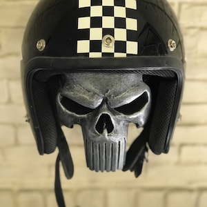 May include: Black motorcycle helmet with a chequered pattern on the top and a silver skull design on the inside.