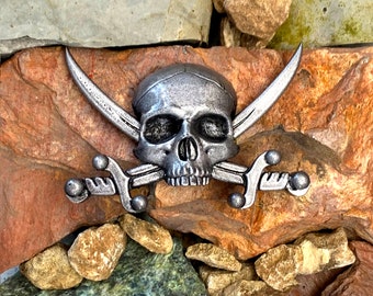 Insignia/pin de resina grande con forma de calavera y cruz en forma de sable.