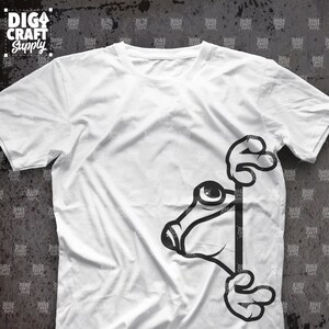 K&ouml;nnte beinhalten: Ein wei&szlig;es T-Shirt mit einem schwarz-wei&szlig;en Cartoon-Frosch, der um die Ecke des Shirts lugt. Der Frosch hat ein gro&szlig;es Auge und h&auml;lt sich mit seinen H&auml;nden am Rand des Shirts fest.