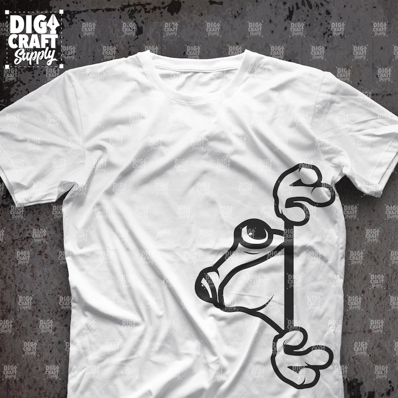 K&ouml;nnte beinhalten: Ein wei&szlig;es T-Shirt mit einem schwarz-wei&szlig;en Cartoon-Frosch, der um die Ecke des Shirts lugt. Der Frosch hat ein gro&szlig;es Auge und h&auml;lt sich mit seinen H&auml;nden am Rand des Shirts fest.