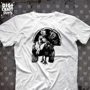 May include: A white t-shirt with a black silhouette of a turkey with its head tucked under its wing.