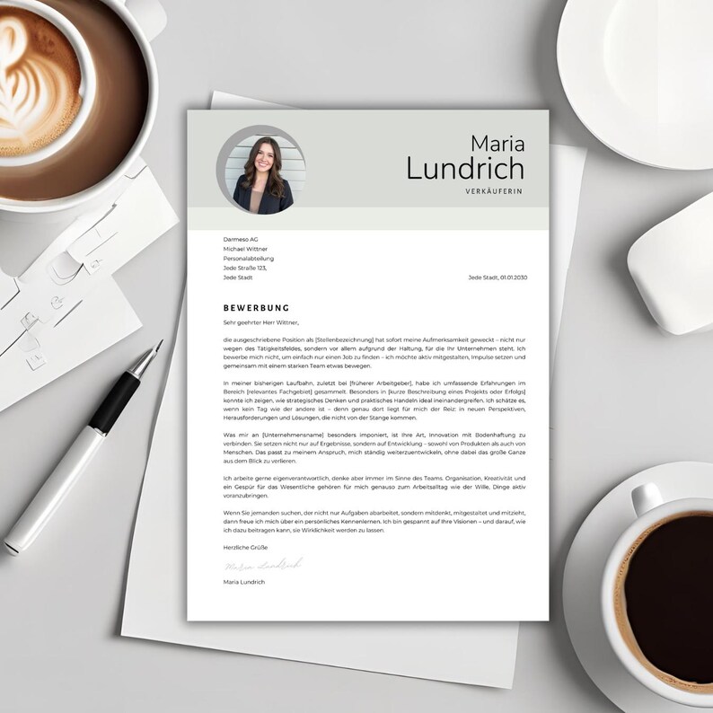 May include: A resume on a light gray background with a photo of a woman in the upper left corner. The resume includes the name "Maria Lundrich" and the word "VERK&Auml;UFERIN" in black text. A cup of coffee and a pen are visible.