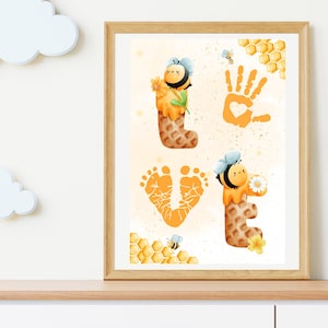 May include: A framed print with a handprint and footprints forming the word "LOVE". Each letter is decorated with a cartoon bee and honeycomb. The background is a light yellow with a subtle texture.