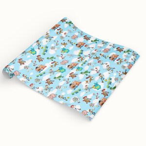 Puede incluir: Un rollo de papel de regalo azul claro con un patr&oacute;n repetido de personajes de dibujos animados, nubes y otros elementos. Los personajes est&aacute;n en varias poses sobre un fondo azul cielo con nubes blancas.