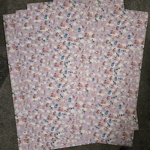 May include: Four sheets of patterned paper featuring a repeating design of cartoon characters, clouds, and other elements on a light purple background. The characters are in various poses and colors.