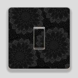 May include: Black light switch cover with a decorative mandala pattern.