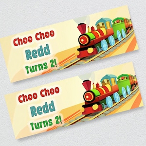 Op de afbeelding: Twee kleurrijke, printbare banners met een cartoon-trein met de tekst "Choo Choo Redd Turns 2!" op elke banner.