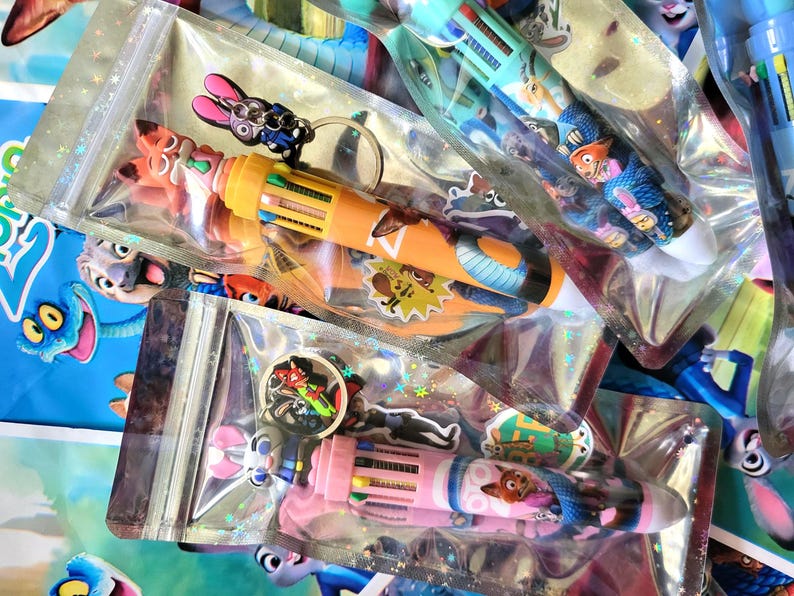 Pu&ograve; includere: Diverse penne multicolori con disegni di personaggi sono confezionate in sacchetti di plastica trasparente. Le penne hanno pi&ugrave; colori di inchiostro e sono decorate con personaggi dei cartoni animati. Alcuni sacchetti includono portachiavi di personaggi.