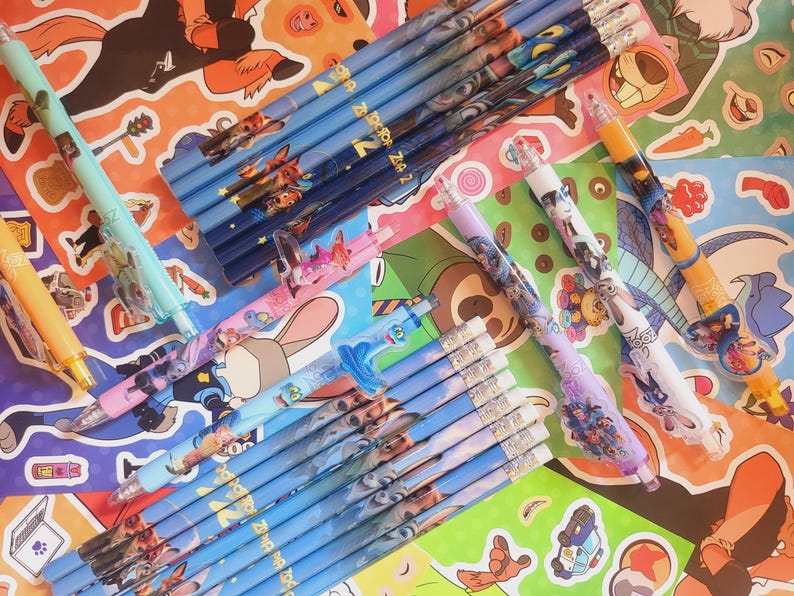 Op de afbeelding: Een verzameling Zootopia-schrijfinstrumenten, waaronder diverse blauwe houten potloden met karakterafbeeldingen, meerdere vulpotloden met kleurrijke plastic behuizingen en verschillende potloodtoppers met figuren.