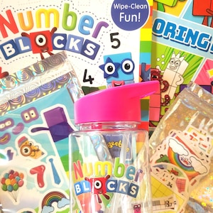 Pode incluir: Uma garrafa de água transparente com tampa rosa e as palavras "Number Blocks" em letras coloridas. A imagem também mostra um livro de atividades Number Blocks, autocolantes e uma caneta de quadro branco.