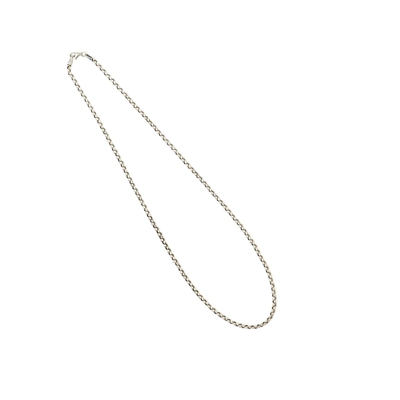K&ouml;nnte beinhalten: Eine silberfarbene Halskette mit filigranem Kettendesign. Die Halskette wird vor einem wei&szlig;en Hintergrund pr&auml;sentiert, der ihre schlichte Eleganz hervorhebt. Die Kette besteht aus kleinen, miteinander verbundenen Gliedern.